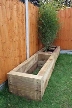 Raised vegetable, flower bed, made with Railway sleepers. Bamboo screening Stock Photos