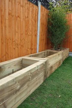 Raised vegetable, flower bed, made with Railway sleepers. Bamboo screening Stock Photos