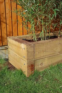 Raised vegetable, flower bed, made with Railway sleepers. Bamboo screening Stock Photos