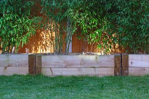 Raised vegetable, flower bed, made with Railway sleepers. Bamboo screening Stock Photos