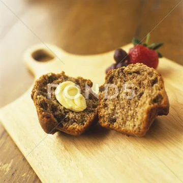 Raisin Bran Muffin Halved with Butter Stock Photos