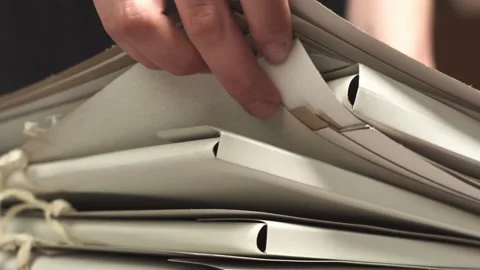 Raising and sorting through folders with hands, searching for the right Stock Footage 156614429