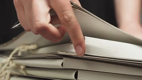 Raising and sorting through folders with hands, counting files, searching for Stock Footage 156614538