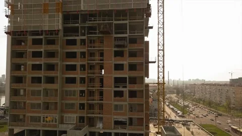 Raising the camera up along a building under construction with empty floor spans Stock Footage 155588237