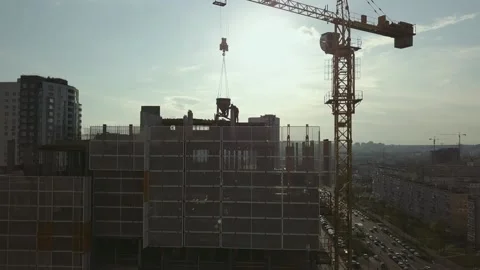 Raising the camera up along a building under construction with empty floor spans Stock Footage 159658455