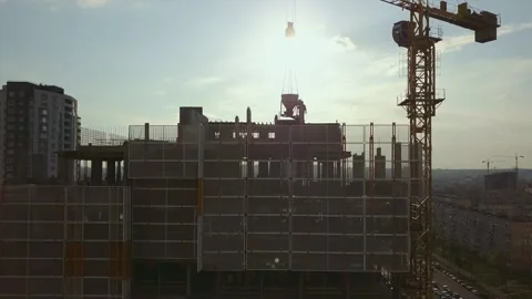 Raising the camera up along a building under construction with empty floor spans Stock Footage 160895111