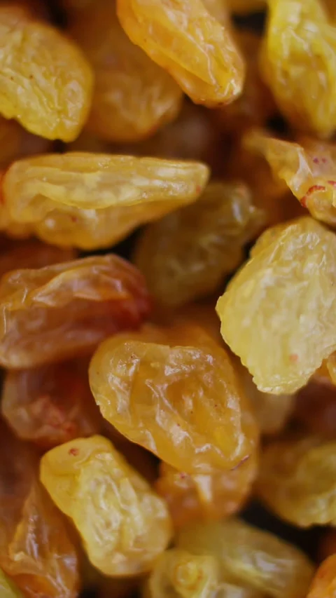 Raisins close up. Loop rotation. Front of the camera rotates plate with raisins. Stock Footage 269315553