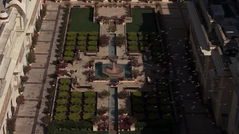 Rajasthani design with arched walkways, stone pathways, and lush green hedges Stock Footage 332728244