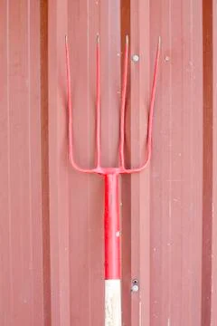 Rake , isolated on red wall , harrow Stock Photos