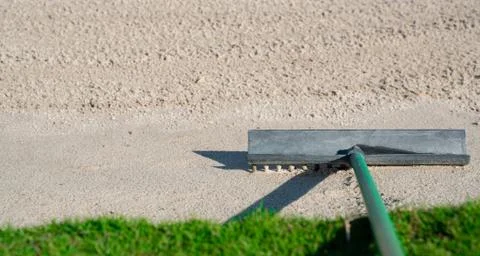 Rake in the sand trap on a golf course Stock Photos