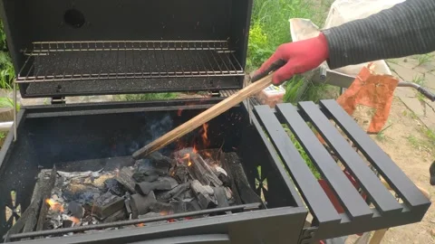 Raking coal with a stick in the grill Stock Footage 155630722