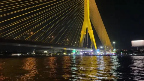 Rama VIII Bridge view yellow light from moving Chao Phraya Boat at night Stock Footage 171511853