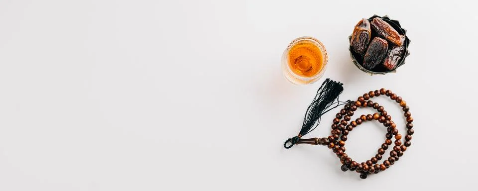 Ramadan flat lay, dates fruit, rosary beads, and tea on a clean white backg.. Stock Photos