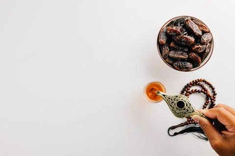 Ramadan flat lay with tea, dates, and prayer beads on a white background. Stock Photos