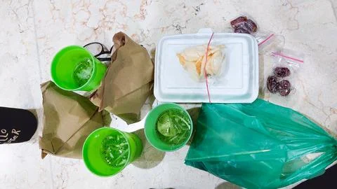 A Ramadan iftar meal consisting of packed rice, beverages, and dates Stock Photos