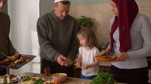 Ramadan iftar meal theme muslim family eating variety foods together on dining t Stock Footage 128409701