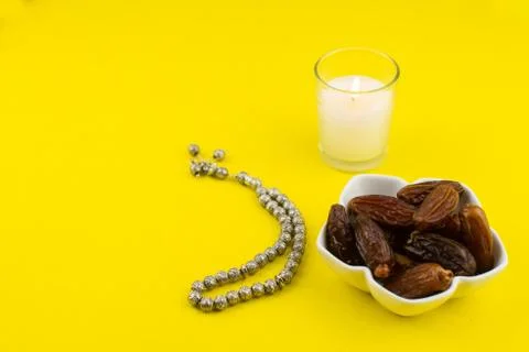Ramadan Kareem Festival. Close up of dried dates fruit in bowl with candle an Stock Photos