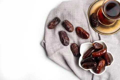 Ramadan Kareem Festive, close up of dates on bowl and cup of black tea on whi Stock Photos