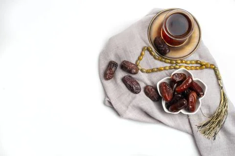 Ramadan Kareem Festive, close up of dates on bowl and cup of black tea on whi Stock Photos