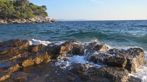 Ramatic sea waves splashing on rocky cliffs Stockbeeldmateriaal 343248425