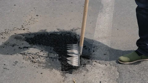 Ramming of asphalt with a rake. Close up the pit with soil in the city. Close-up Stock Footage 162040254