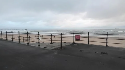 Ramp to beach small waves and distant pier Stock Footage 260504031