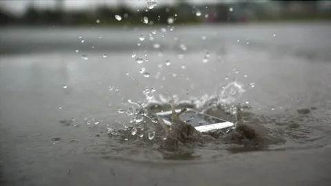 Ramped speed dropping phone in puddle Stock Footage 153290528