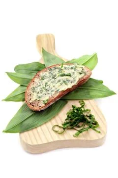 Ramson butter on slice of brown bread with fresh leaves. Stock Photos