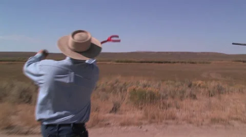 A ranch hand throws a clay pigeon up in the air for some skeet shooting Stock Footage 56246065