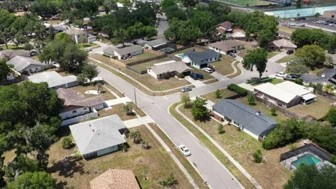 Ranch-style homes with backyard swimming pools line quiet cul-de-sac street in Stock Footage 340856921