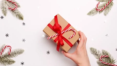 Рand put christmas gift box with red bow on festive New Year background Stock Footage 144657847