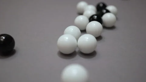Random collisions of black and white balls on gray suface Stock Footage 147108563