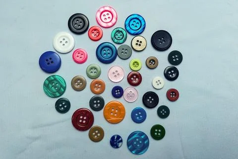 Random colorful buttons on fabric texture Фото