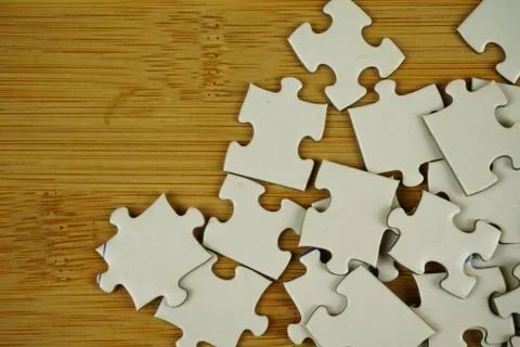 Random jigsaw puzzle incomplete concept on wooden background. Copy space for Stock Photos