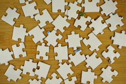 Random jigsaw puzzle incomplete concept on wooden background. Copy space for Stock Photos