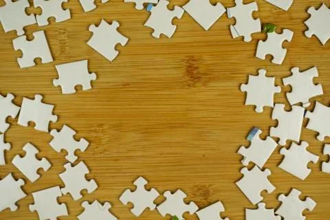 Random jigsaw puzzle incomplete concept on wooden background. Copy space for Stock Photos