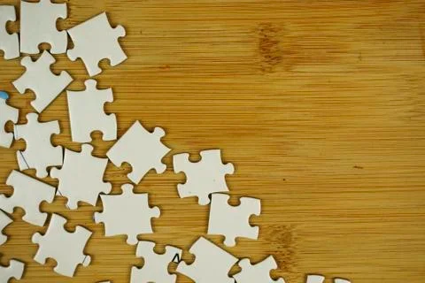 Random jigsaw puzzle incomplete concept on wooden background. Copy space for Stock Photos