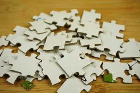 Random jigsaw puzzle incomplete concept on wooden background. Copy space for Stock Photos