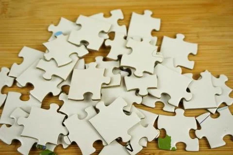 Random jigsaw puzzle incomplete concept on wooden background. Copy space for Stock Photos