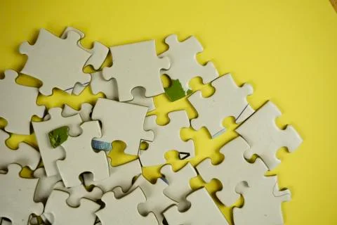 Random jigsaw puzzle incomplete concept on yellow background Stock Photos