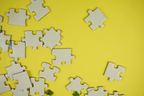 Random jigsaw puzzle incomplete concept on yellow background Stock Photos