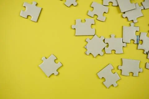 Random jigsaw puzzle incomplete concept on yellow background Stock Photos