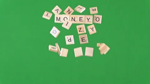 Random letters on tiles being thrown in the air in slow motion spelling money 動画素材 100694061