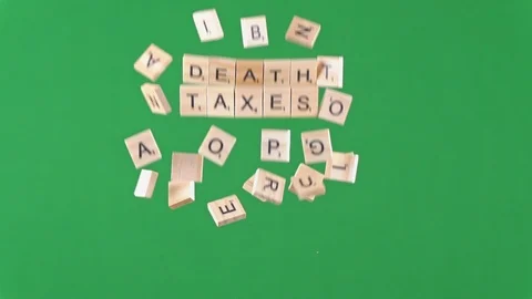 Random letters on tiles thrown in the air in slow motion spelling death, taxes 動画素材 100693955