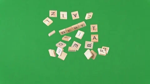 Random letters on tiles thrown and falling in slow motion spelling the word debt 動画素材 100694072