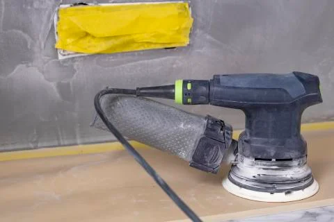 Random-orbit disc sander, refinishing piece of custom sand stucco Stock Photos