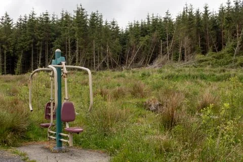 A random piece of exercise equipment in a field next to a forest Stock Photos