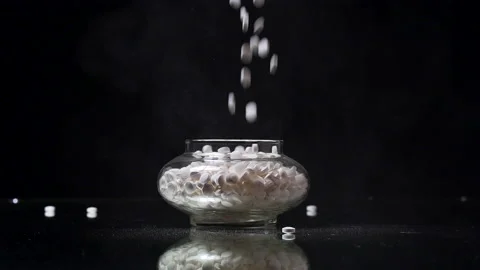 Random Pills being dropped into an antique jar in slow motion 120fps Stock Footage 197085511