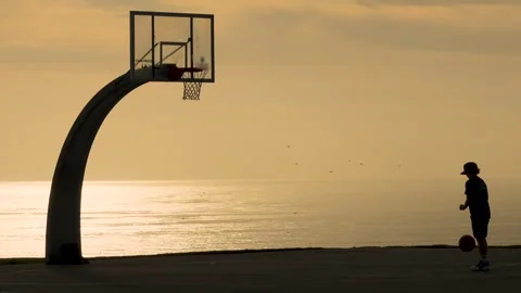 Random player playing basketball silhouette by the beach Stock Footage 295411490