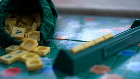Random Scrabble game letter tiles with score value coming out Stock Footage 126350014